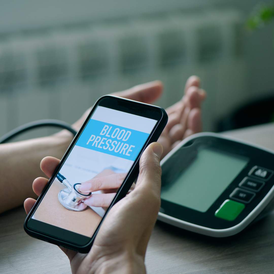 Person taking blood pressure with phone in hand where you can see the result