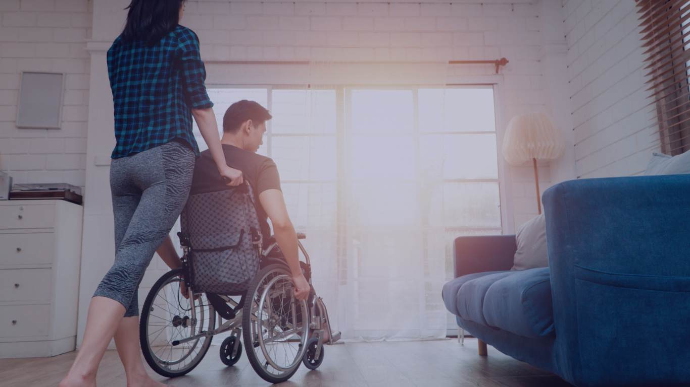 man in a wheelchair with his wife in the living room of the house