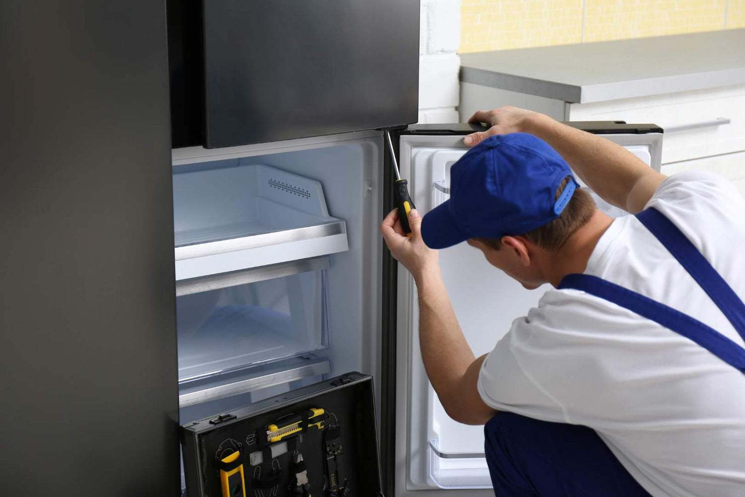 a person repairing a refrigerator