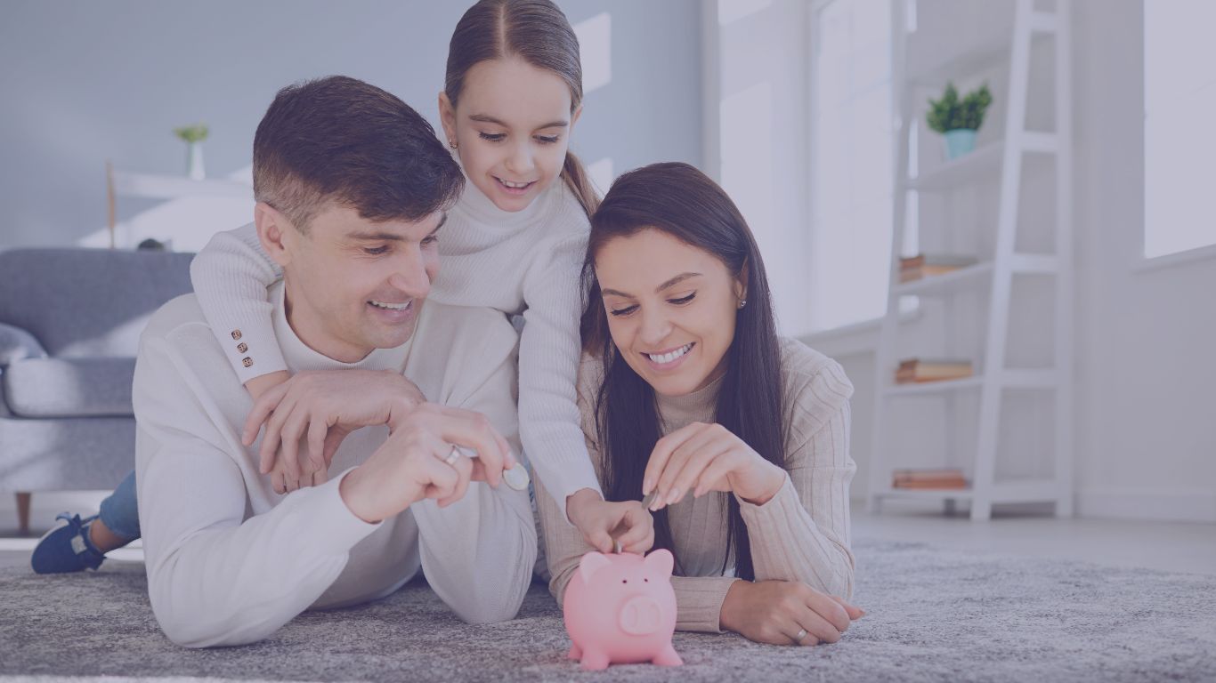 family on the floor of their house putting coins into a piggy bank