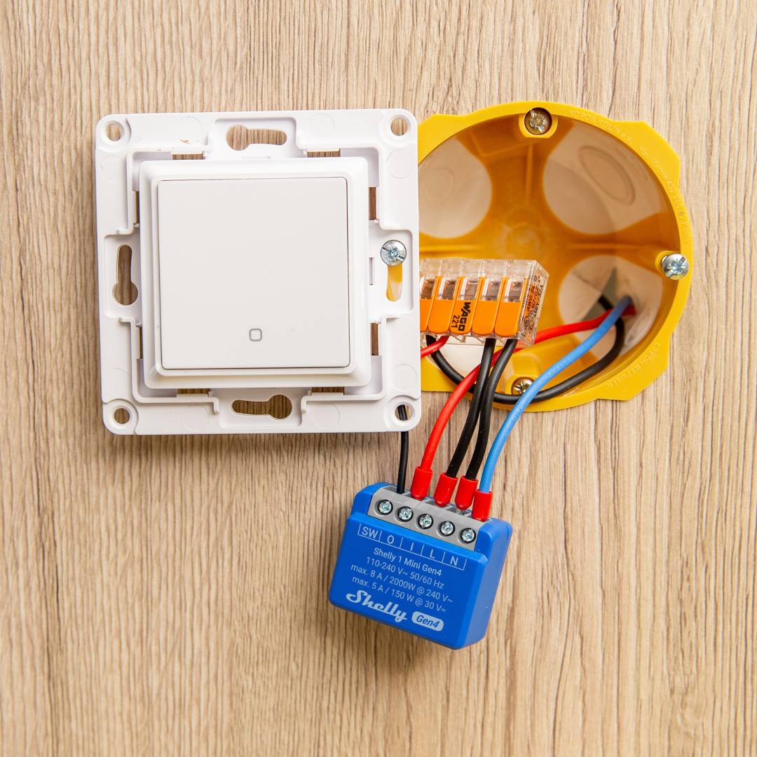 Electrical switch panel with wiring and a blue control module on a wooden surface