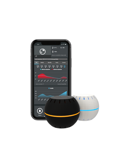 a Shelly black and white sensor. in the background a mobile phone with the shelly app
